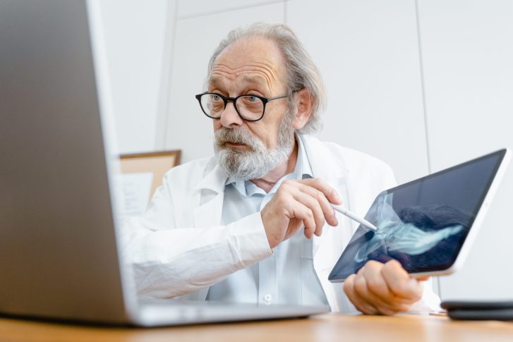 A male doctor explaining the x ray result of a foot