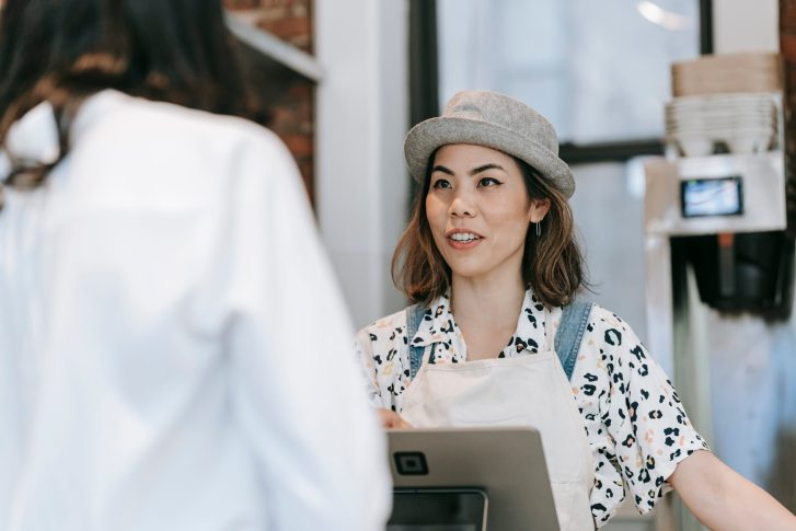 A woman at a counter talking to a customer
