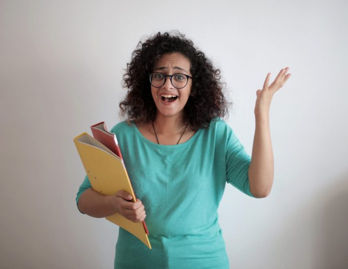 Adult displeased businesswoman with papers in light modern office