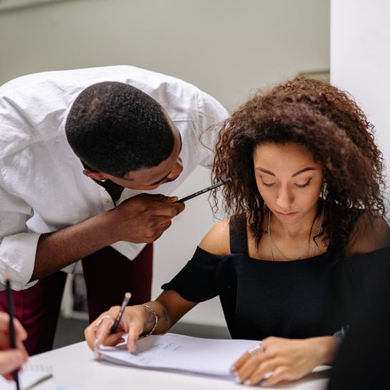 A man pointing a pencil to a woman