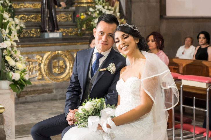Newlywed couple sitting in church