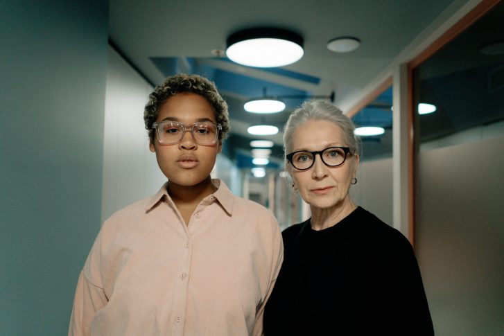 Woman in pink button up shirt wearing black framed eyeglasses