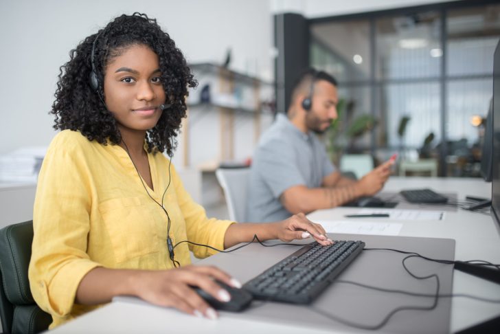 Woman in yellow blouse working in a call center office